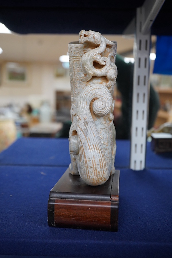 A large Chinese archaistic pale celadon and calcified jade rhyton, on a hardwood stand, 17.5cm high. Condition - fair to good.